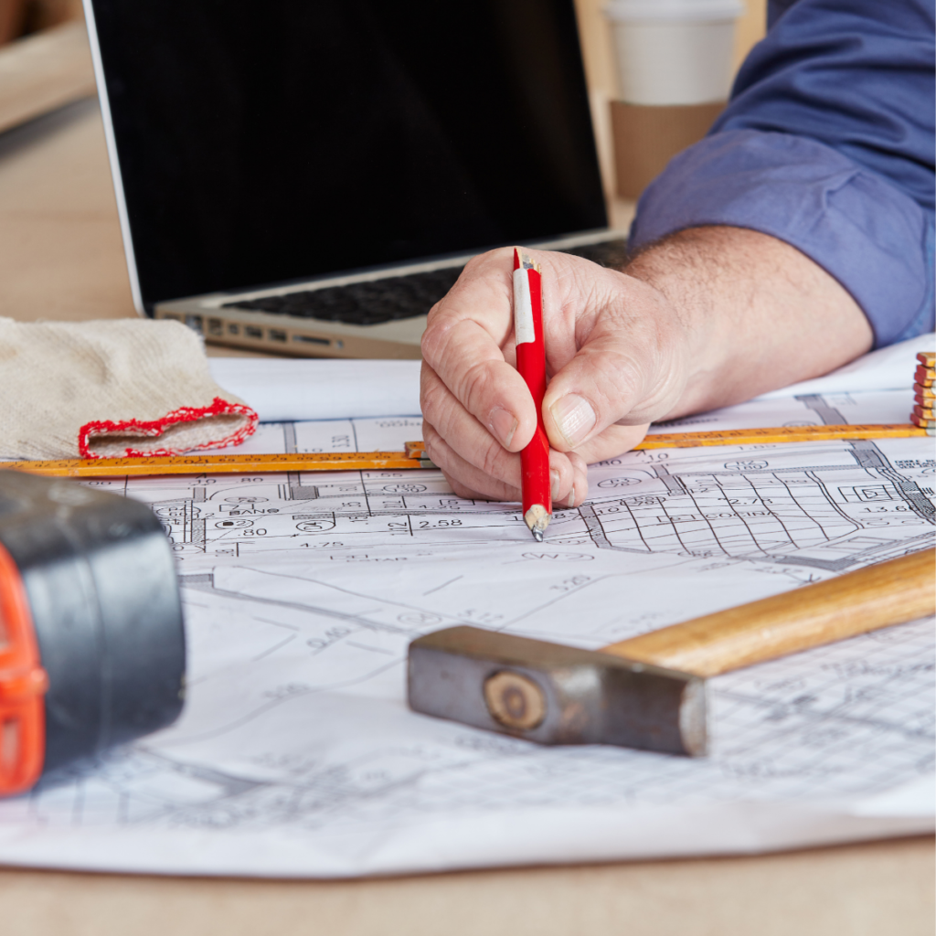 Printed woodworking plans spread across a workbench